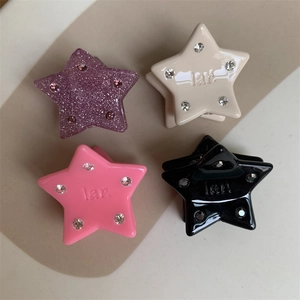 Detail showing colorful mini star hair clips with glitter and embedded rhinestones