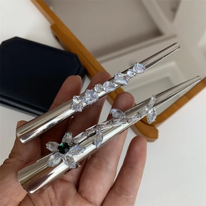 Barrette argentée élégante avec zircons blancs et fleur ornée d'une pierre verte