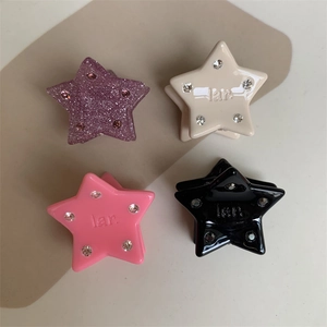 Detail view of colorful star mini hair claws with inlaid rhinestones and resin finish