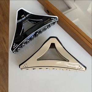 Close-up of geometric triangle hair claws with rhinestones and Barrette la France text