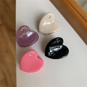 Close-up of heart-shaped mini hair clips with rhinestones in four assorted colors