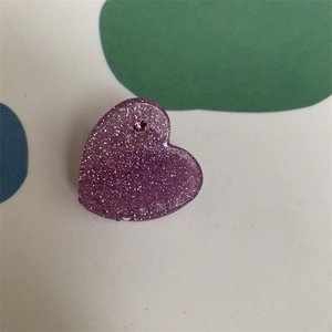 Detail of purple glitter heart hair clip featuring a small pink rhinestone inlay