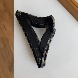 Detail view of large geometric hair claw with tortoiseshell pattern and crystals