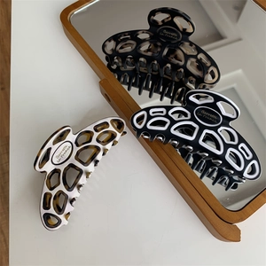 Detail of hollow acetate hair claw clips with Barrette La France text and tortoiseshell pattern