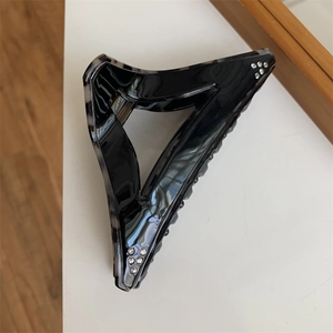 Detailed view of large marble pattern hair claw clip with silver rhinestones on corners