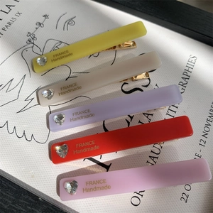 Close-up of colorful resin hair clips with heart diamonds and gold France handmade lettering