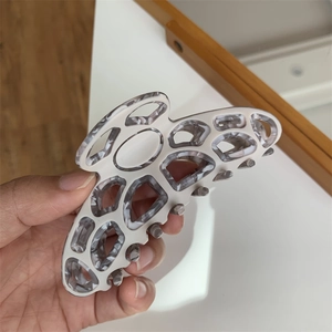 Detail of butterfly hair claw clip with grey marble texture shown in hand