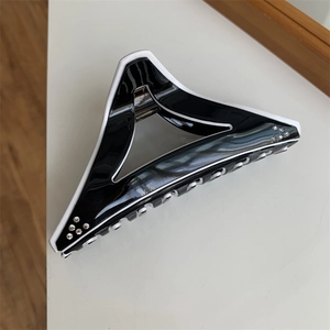 Detailed view of large black and white geometric triangle hair claw clip with rhinestones