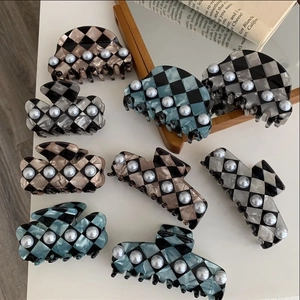 Detailed view of checkerboard hair claws with elegant pearl trim in various colors