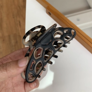 Close-up of a large tortoiseshell and black two-tone geometric hair claw clip for long hair