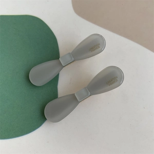 Detailed close-up of two grey bow-shaped acetate hair clips with Creation France text