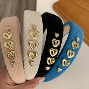 Detail showing diagonal weave fabric headband with golden heart metal and rhinestone accents