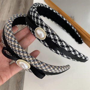 Elegant houndstooth headband with black ribbon bow and pearl detail in French vintage style