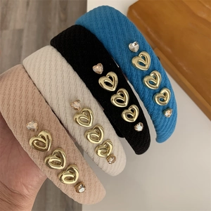 Close-up of knit fabric headbands featuring gold heart charms and crystal rhinestones