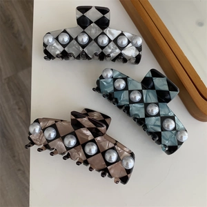 Detail of checkered hair claws with inlaid pearls in black, blue, and coffee colors