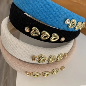 Detailed view of textured knit headbands featuring gold heart charms and rhinestones