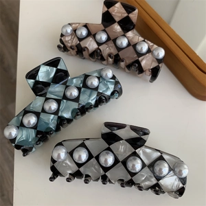Checkerboard acetate hair claws with inlaid pearls in brown, blue, and white colors