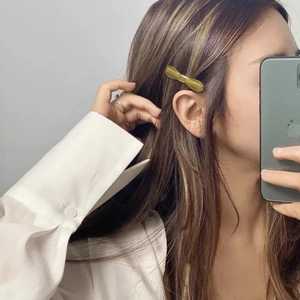Minimalist acetate hair clip in translucent olive yellow shown on side swept hair