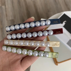 Detail showing set of four colorful pearl hair clips with Barrette La France gold lettering