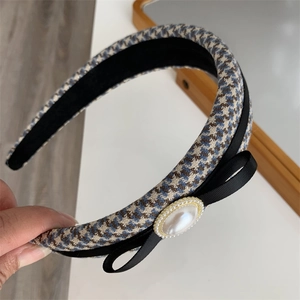 Elegant houndstooth headband with black bow and vintage pearl detail for women