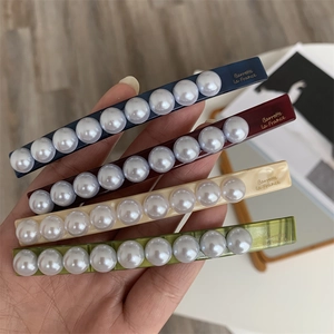 Detail showing four assorted pearl hair clips with Barrette La France gold lettering