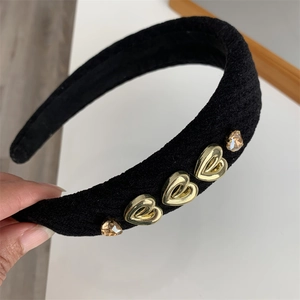 Detail of black velvet headband featuring golden metal hearts and amber crystal accents