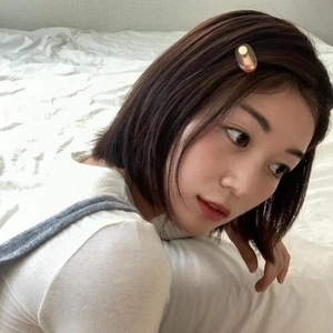 Close-up of minimalist amber oval hair clip worn on model's dark brown short hair