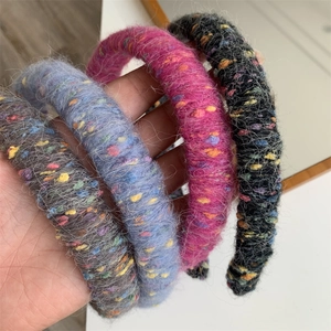 Detail of wool-wrapped headbands in grey, blue, magenta, and black with fuzzy texture