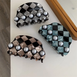 Detailed view of checkered hair claws with pearl accents in black, blue, and apricot colors