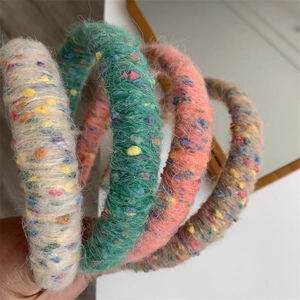Detail showing the thick knitted texture and colorful speckled wool yarn on headbands
