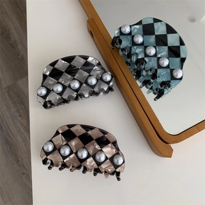 Detail of checkerboard acetate hair claws with white pearl accents in various colors