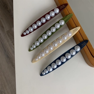 Detail view of four colored barrettes with gradient pearls and Barrette la France text