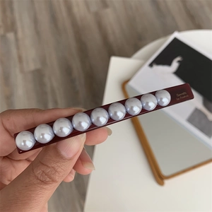 Detail view of burgundy pearl hair clip with gold Barrette La France lettering