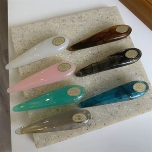 Detail of colorful acetate teardrop hair clips with marble texture on stone slab