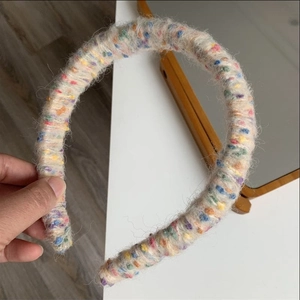 Close-up of rainbow knitted headband with colorful yarn texture and thick padded design