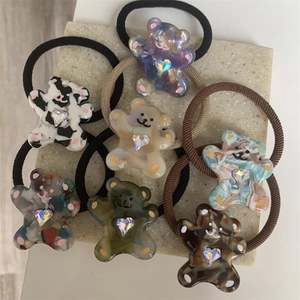 Detailed macro view of seven acrylic bear hair ties with heart shaped rhinestones