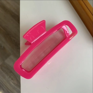 Detail of glossy pink rectangular hair claw clip with golden Handmade text engraving
