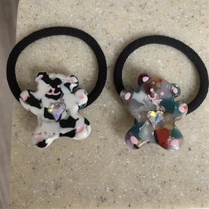 Close-up of cute cartoon bear hair ties with heart crystals and colorful textures