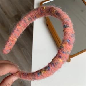 Close-up of pink fuzzy rainbow headband with colorful knitted wool texture details