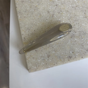 Close-up of translucent grey acrylic hair clip with a gold PONY FOESSA brand logo detail
