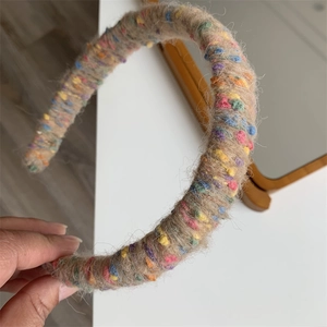 Close-up of rainbow knit headband with colorful polka dots and fluffy wool texture