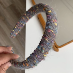 Detailed macro view of the soft grey knit texture and rainbow wool fibers of the headband