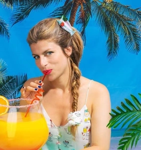 Close-up of a blue candy-shaped hair clip worn by a model in a summer beach setting