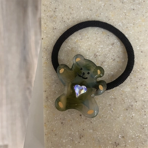 Detail of cute bear hair tie with sparkling heart crystal and yellow ear accents