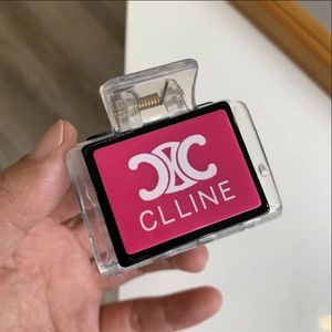 Detailed macro view of the pink decorative panel with white logo on a transparent hair claw