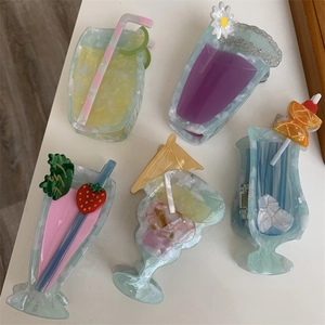 Detail view of five assorted acetate cocktail-shaped hair claws with vibrant colors