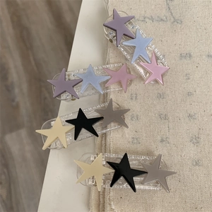 Detailed view of matte star-shaped hair clips in pastel and neutral colors for women