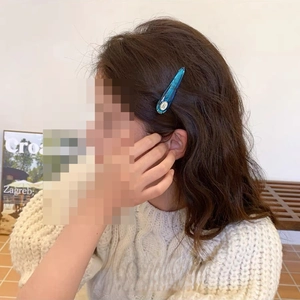 Elegant blue translucent acrylic drop hair clip worn on a woman's side hair