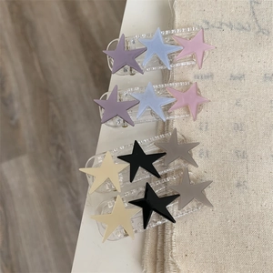 Close-up of star hair clips featuring three colorful stars on a clear duckbill clip