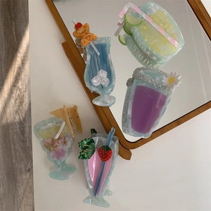 Detailed view of colorful cocktail-shaped acetate hair claws with 3D fruit and straw accents